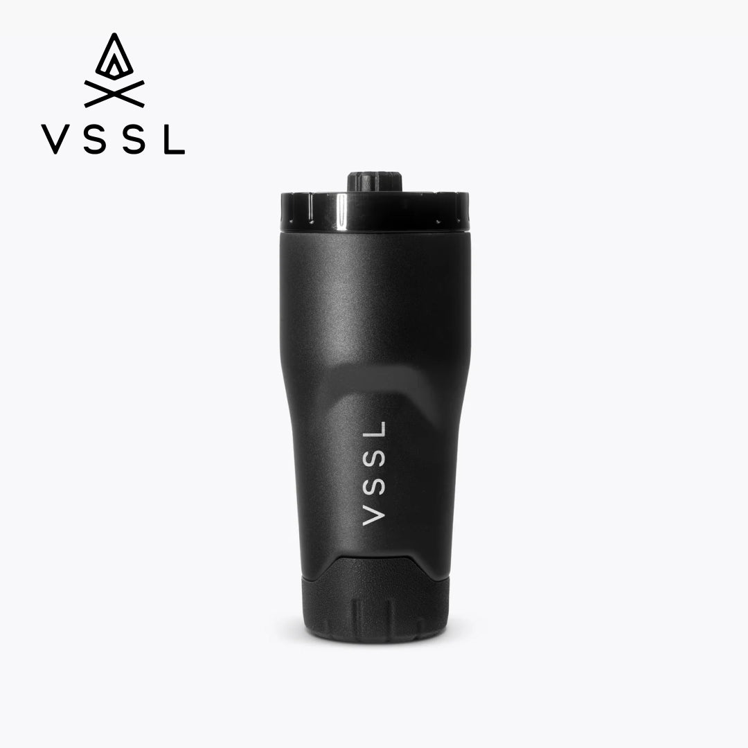 A matte black VSSL travel tumbler with a matching black lid, shown on a light gray background with the VSSL logo in the top-left corner.
