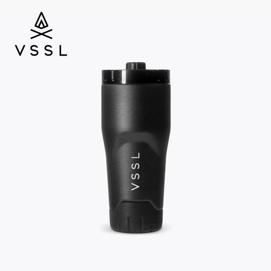 A matte black VSSL travel tumbler with a matching black lid, shown on a light gray background with the VSSL logo in the top-left corner.