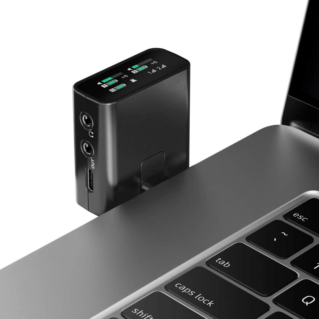 Black electronic device attached to a laptop on a white background