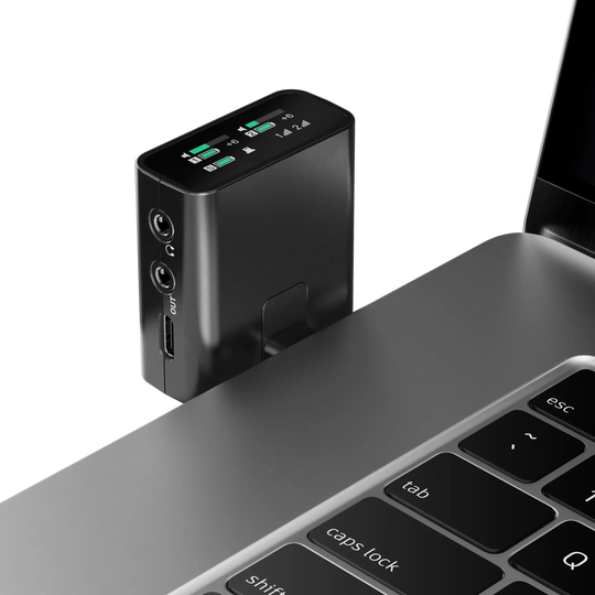 Black electronic device attached to a laptop on a white background