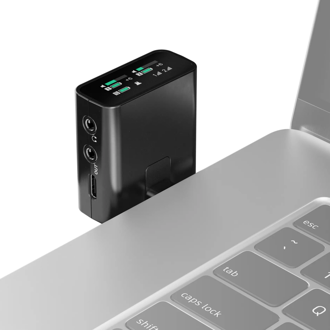 Black electronic device with digital display attached to a laptop on a white background