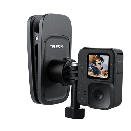 A black action camera shown with its magnetic clip mount attached, on a plain white background. The camera&