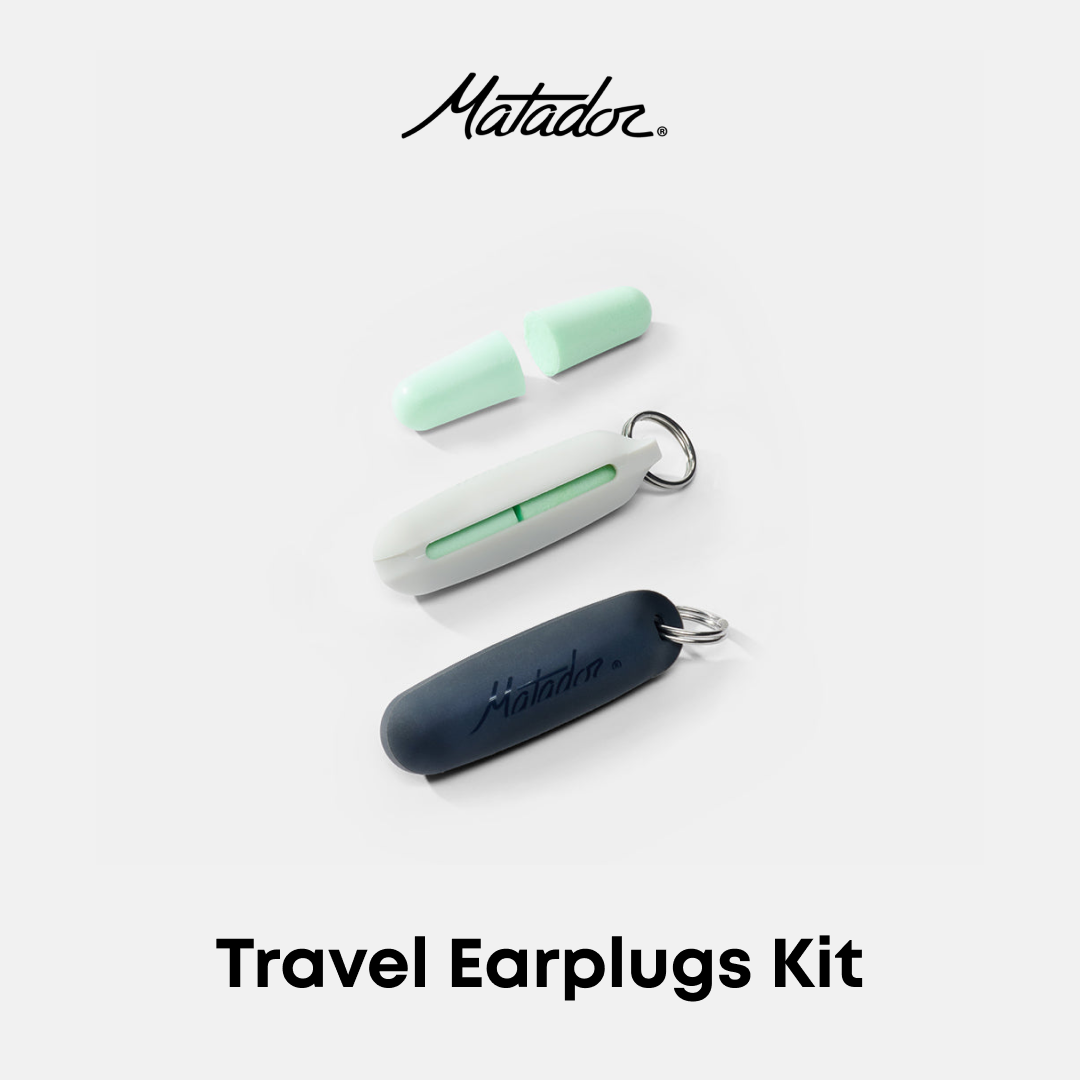 Matador Travel Earplugs Kit featuring three earplugs in mint green, white, and dark navy blue, arranged on a light gray background with the Matador logo at the top and &