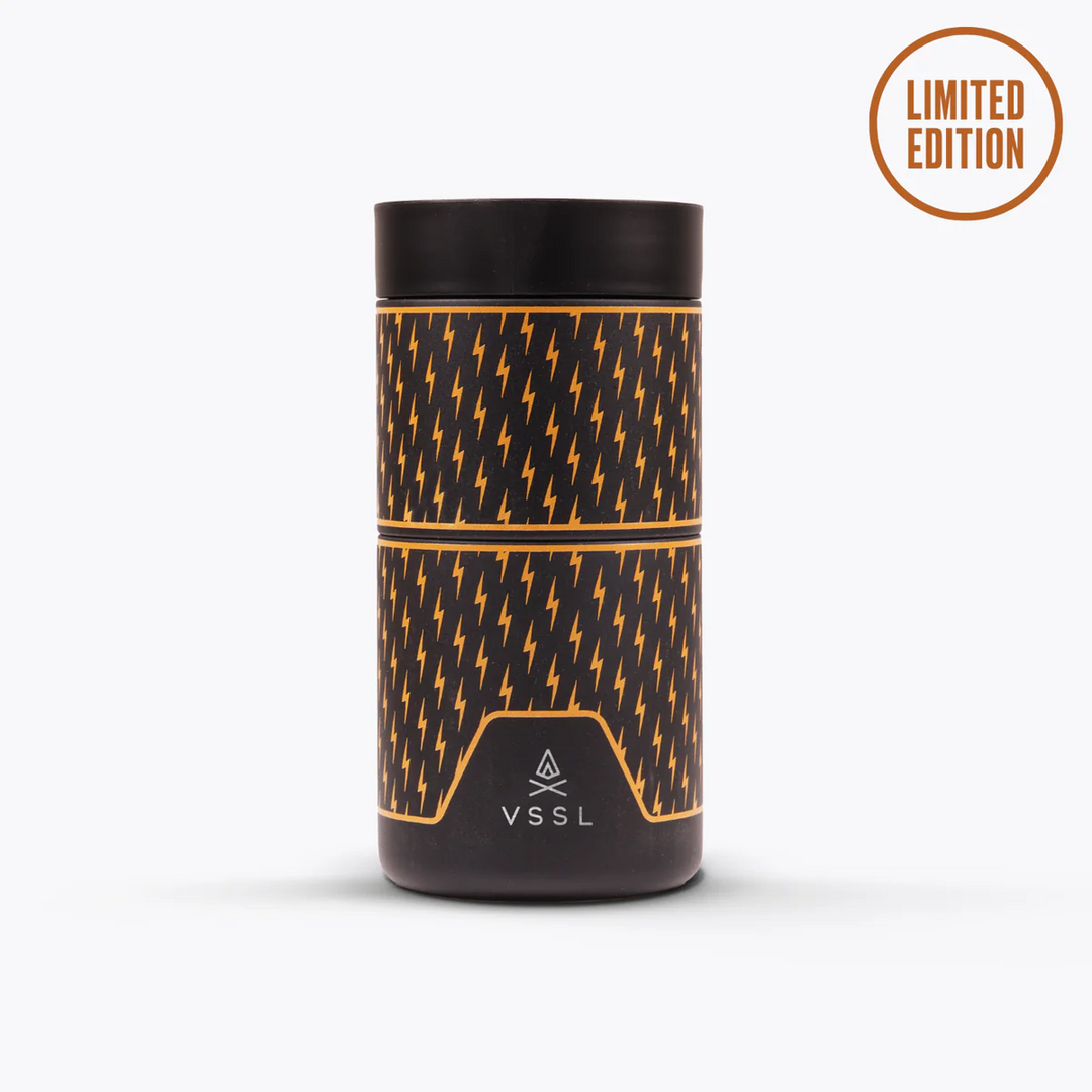 A VSSL limited edition cylindrical container with a black and orange lightning-bolt pattern, shown on a light gray background with a &