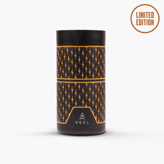 A VSSL limited edition cylindrical container with a black and orange lightning-bolt pattern, shown on a light gray background with a &