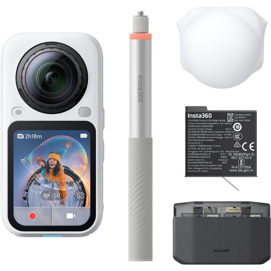 Insta360 action camera shown with included accessories on a white background: a white handheld camera with a large front lens and screen, a white selfie stick, a white protective cover, a black Insta360 battery, and a black charging dock.