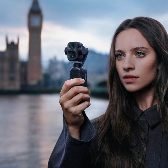 Woman holding a DJI Osmo Pocket 4P camera with Big Ben in the background