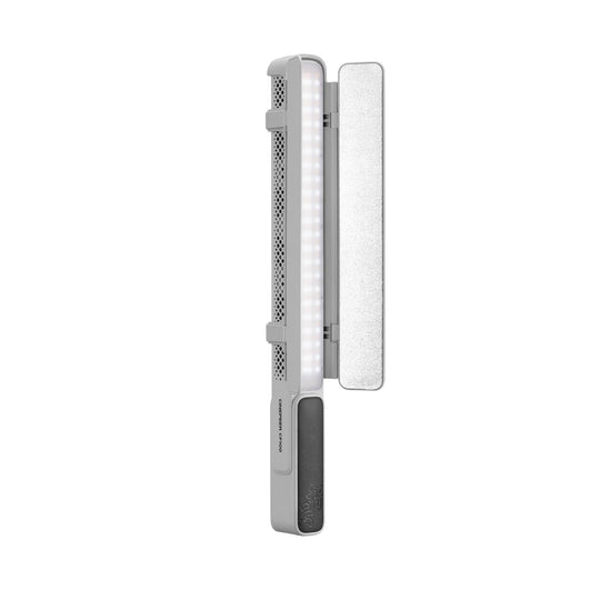 A portable LED light panel with a silver and gray body, featuring a vertical array of illuminated white LEDs, a textured silver side panel, and a dark gray power button on a solid white background.