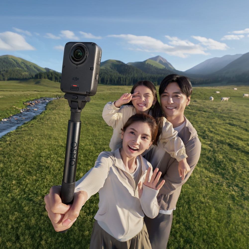 a family taking selfie with dji osmo 360 II against a beautiful landscape