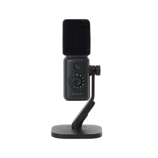 Direct front view of the black amaran Mic Desktop Stand Kit showing the foam windscreen, mute button, gain adjustment dial with LED indicator lights, and desktop stand against a transparent background.
