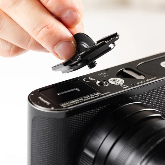 Person attaching a lens cap to a camera