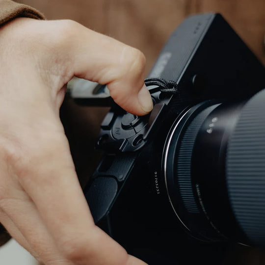 Hand adjusting a camera lens on a camera body