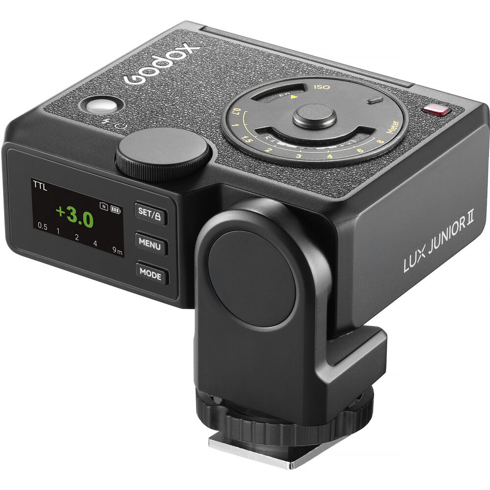 Three-quarter perspective view of the Godox Lux Junior II Retro Camera Flash highlighting the digital rear display screen, side control buttons, tilt pivot mechanism, top analog calculation dial, and hot shoe mount foot.