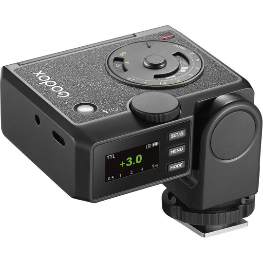 Rear high-angle perspective of the Godox Lux Junior II Retro Camera Flash showing the active LCD control screen, USB-C charging port, top control wheel, analog calculation dial, and hot shoe locking wheel base.