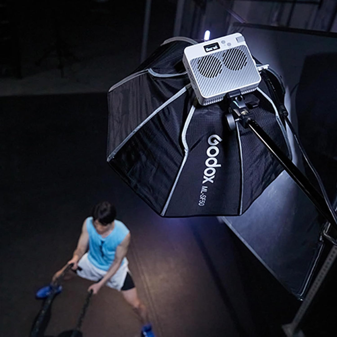 A Godox ML-SF50 softbox mounted on a light stand, providing directional lighting for an athlete training in a gym setting.