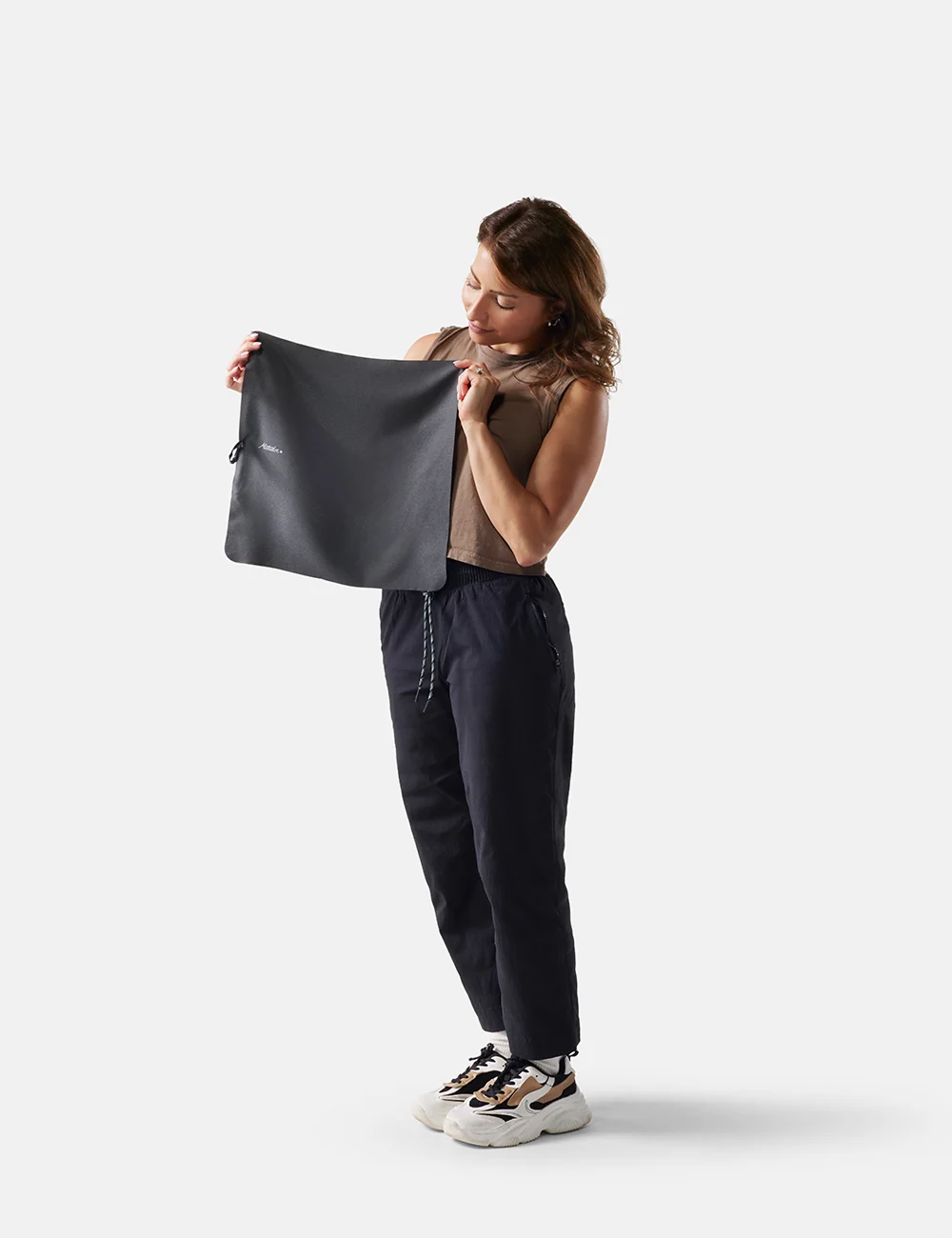 Woman holding a black bag against a white background