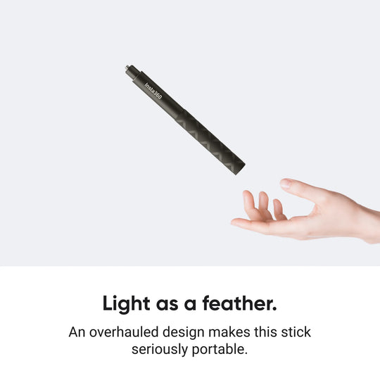 Collapsed Insta360 114cm Invisible Selfie Stick hovering lightly above an open hand against a plain studio background to highlight its lightweight and portable overhaul design.
