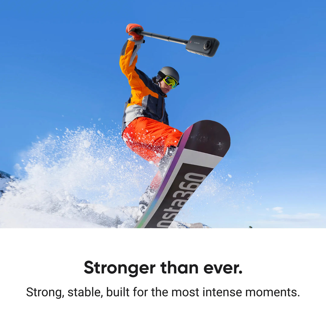 Snowboarder jumping in mid-air while holding the extended Insta360 114cm Invisible Selfie Stick with an action camera to highlight high stability and durability during high-intensity sports.