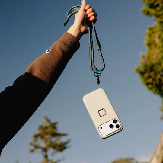 Phone case with a lanyard held up against a blue sky
