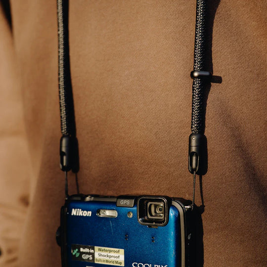 close up shot of a person wearing peak design black mobile crossbody strap