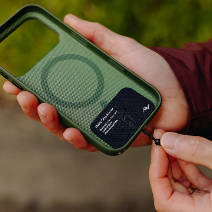 hand holding a green mobile phone case with peak design mobile strap adapter attached