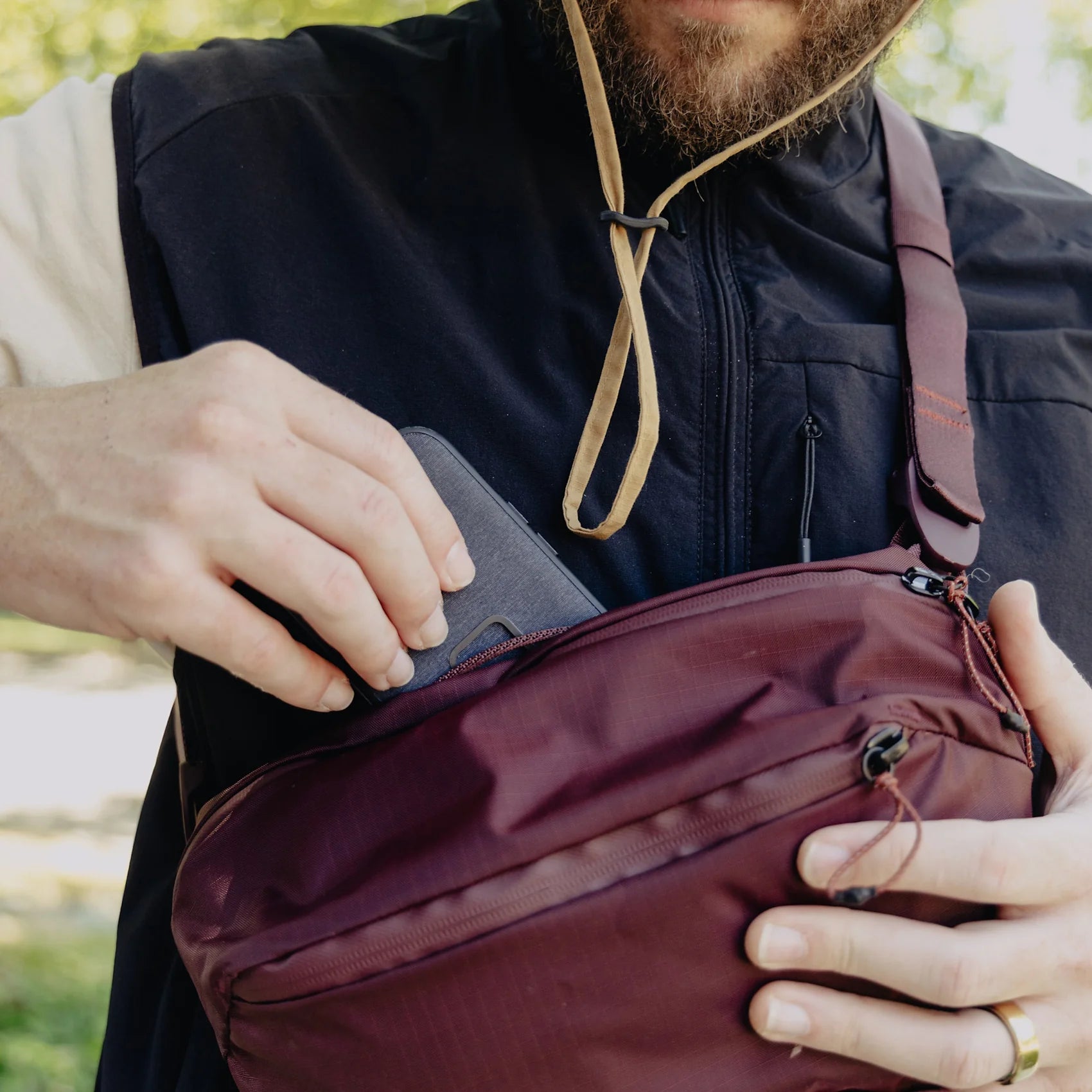 Person holding a peak design outdoor sling bag outdoors