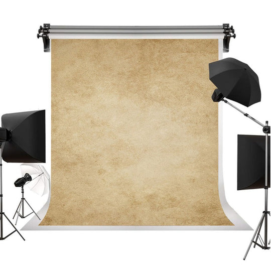 A photography backdrop set with a large beige textured backdrop roll suspended on a stand, surrounded by studio lights and softboxes on a white background.