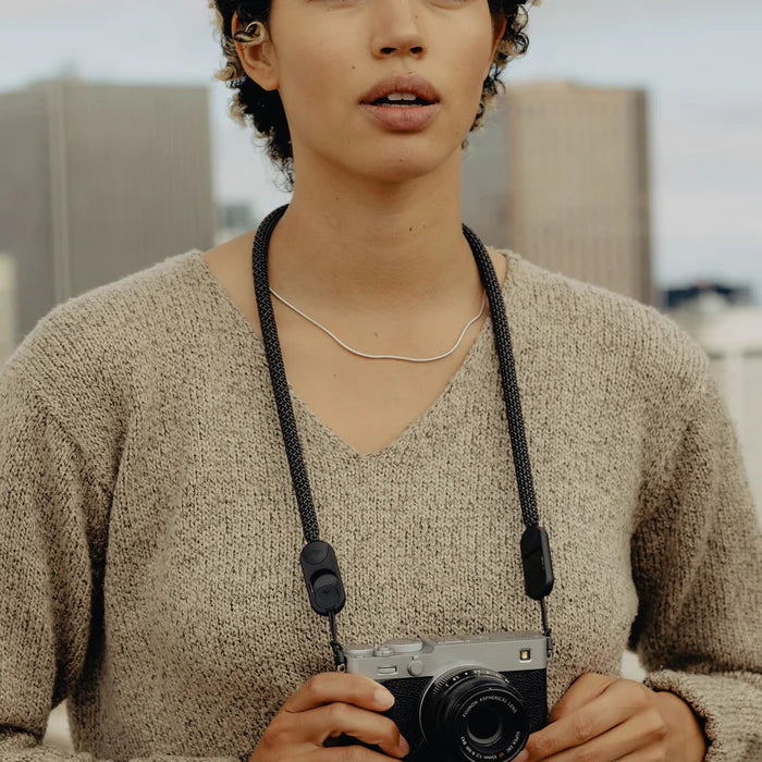 Person holding a camera with a blurred indoor background