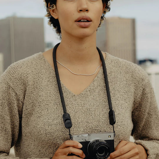 Person holding a camera with a blurred indoor background