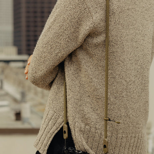 Close-up of a person wearing a Peak Design Form Rope Camera Strap with a blurred background