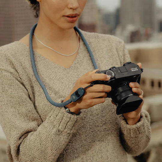Person holding a camera with a blurred indoor background