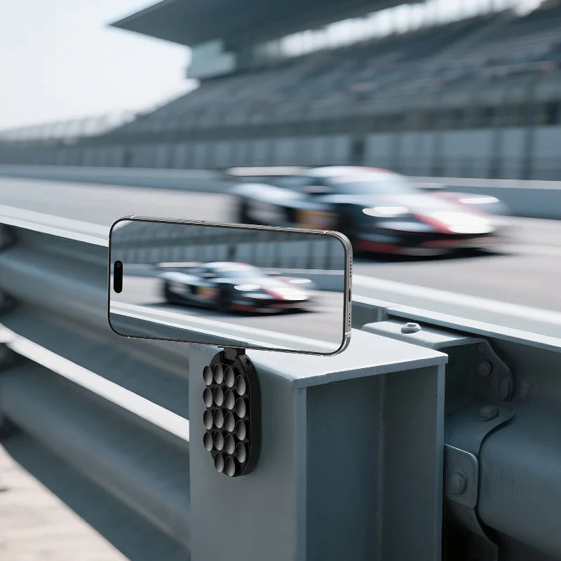 Ulanzi MA39 MagLock suction mount attached to a metallic race track guardrail holding an iPhone to capture trackside action shots.